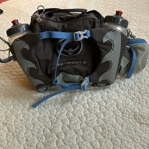 Osprey Tempest 6 women’s hip pack w two water bottles.  Gray body w blue straps